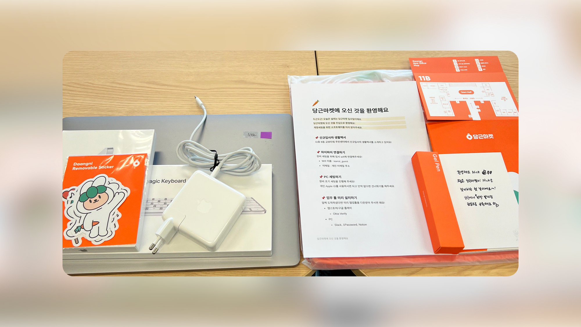 Banner image showing onboarding goods such as MacBook, charger, sticker, guide, etc.